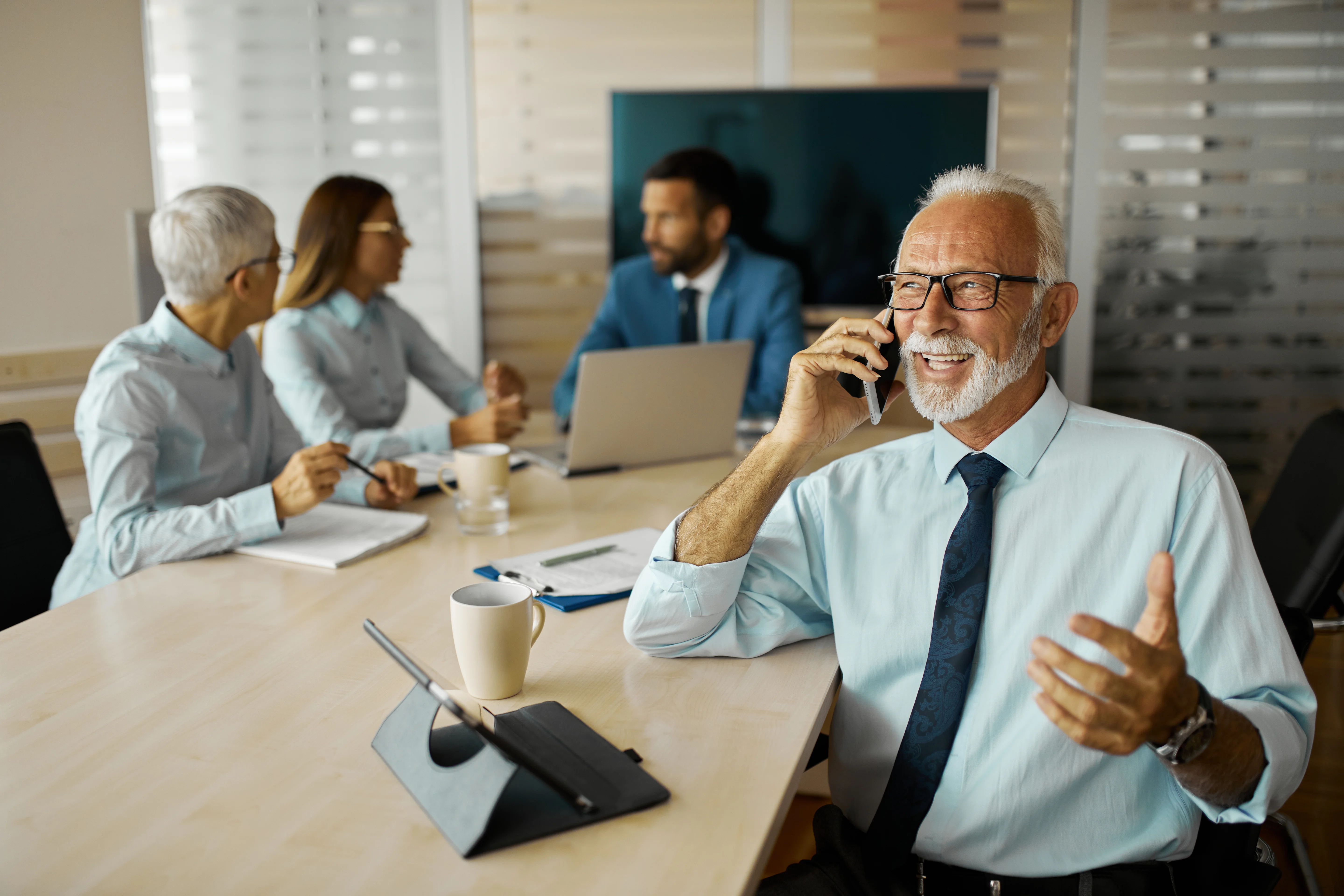 A senior business executive using a mobile phone in the office.