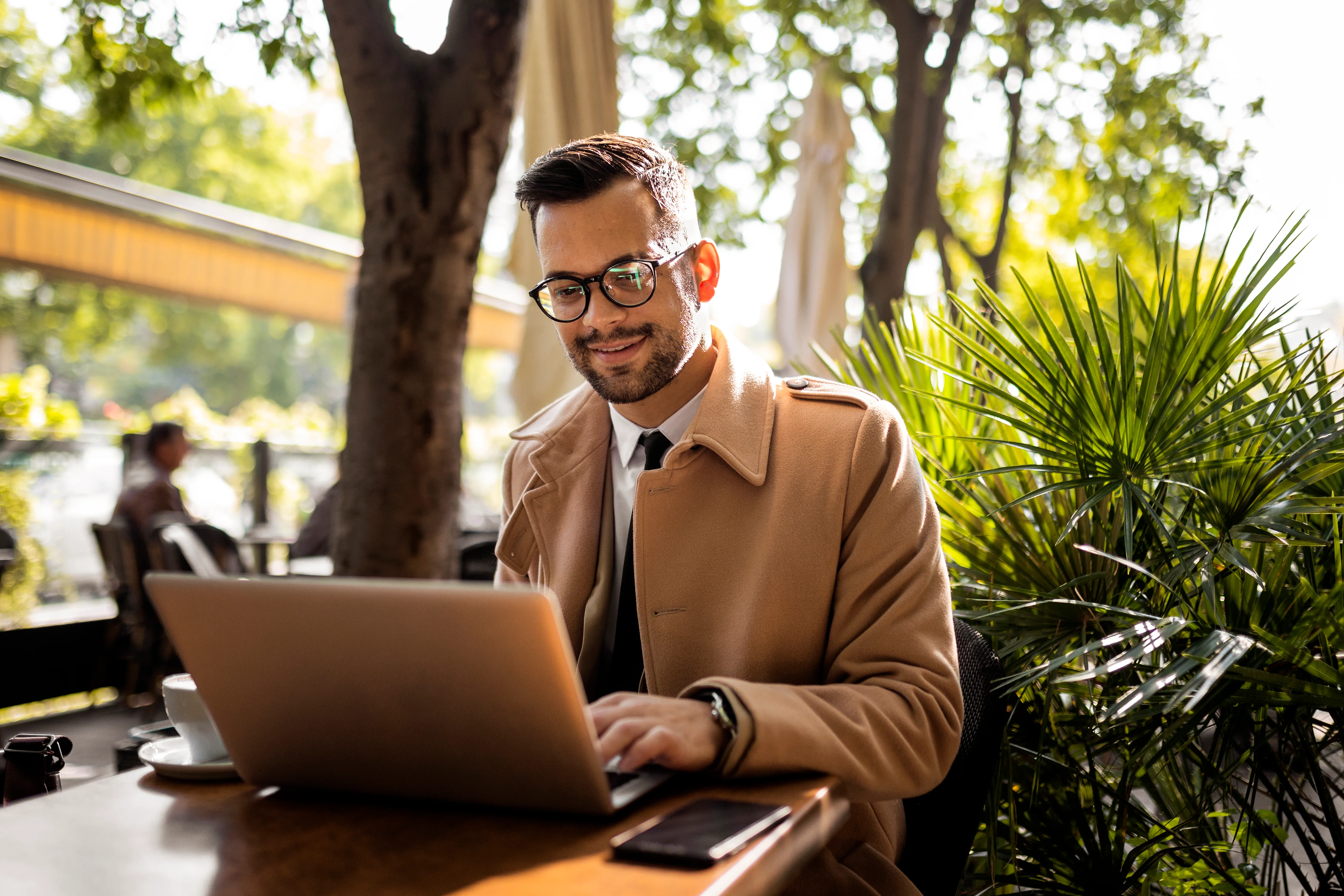 A business man working on a laptop in a cafe.